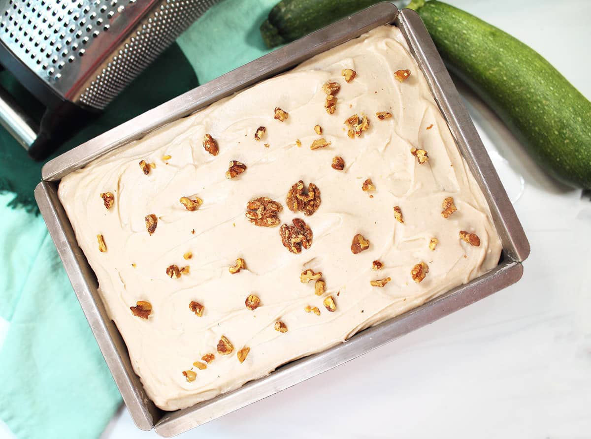 Frosted zucchini spice cake decorated with walnuts.