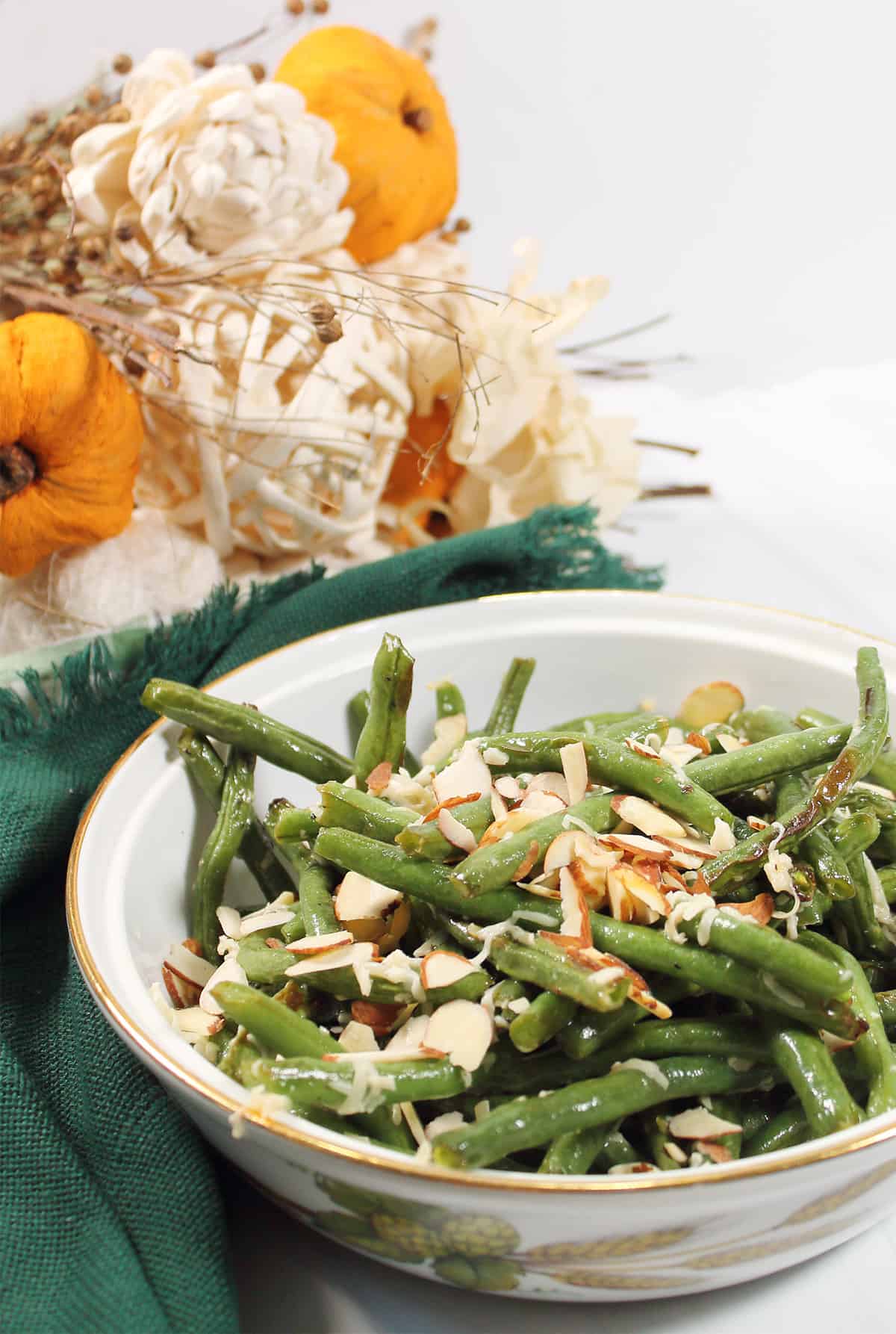 Partial view of bowl of air fryer green beans with green napkin.