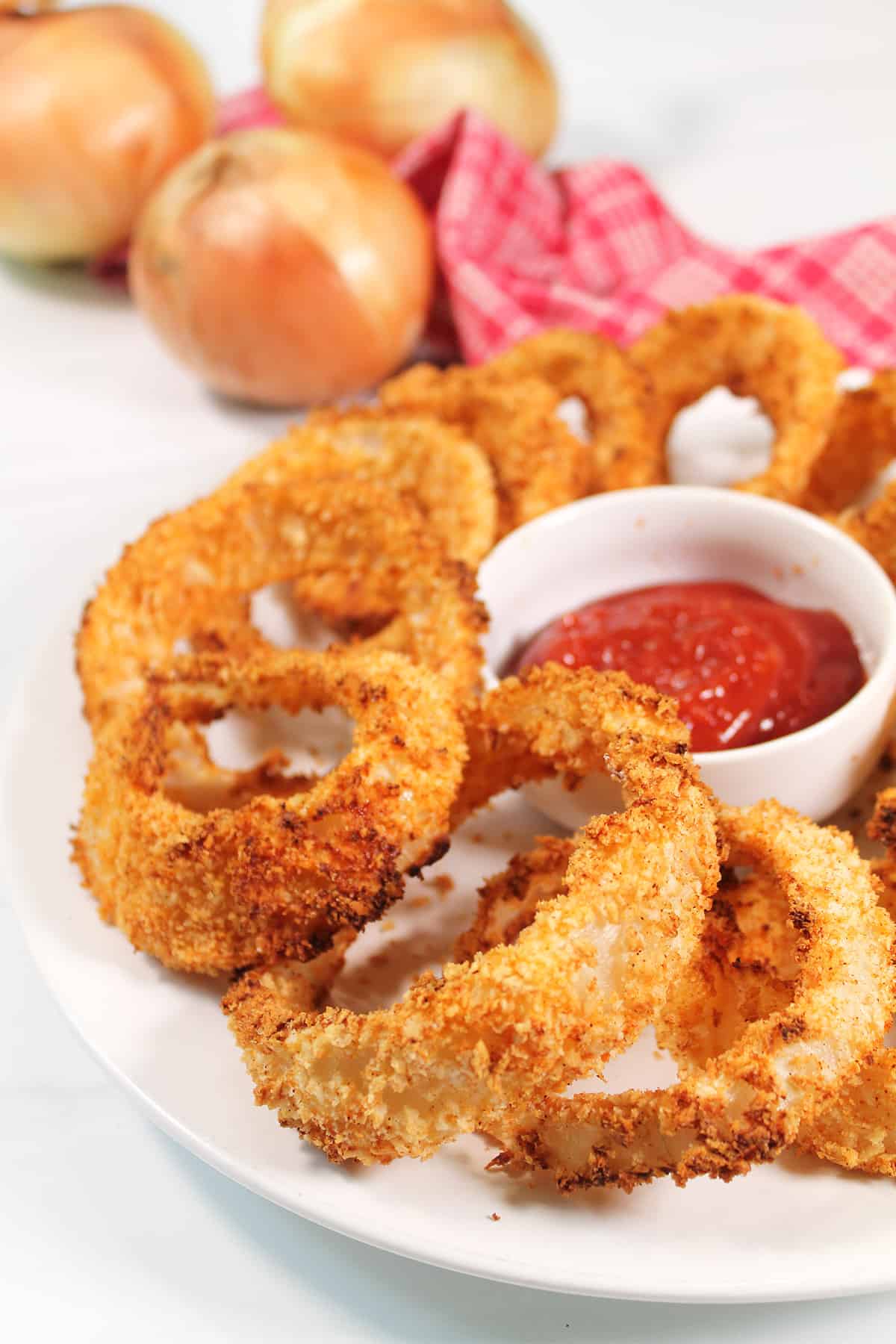 Air Fried Onion Rings on white plate with ketchup.