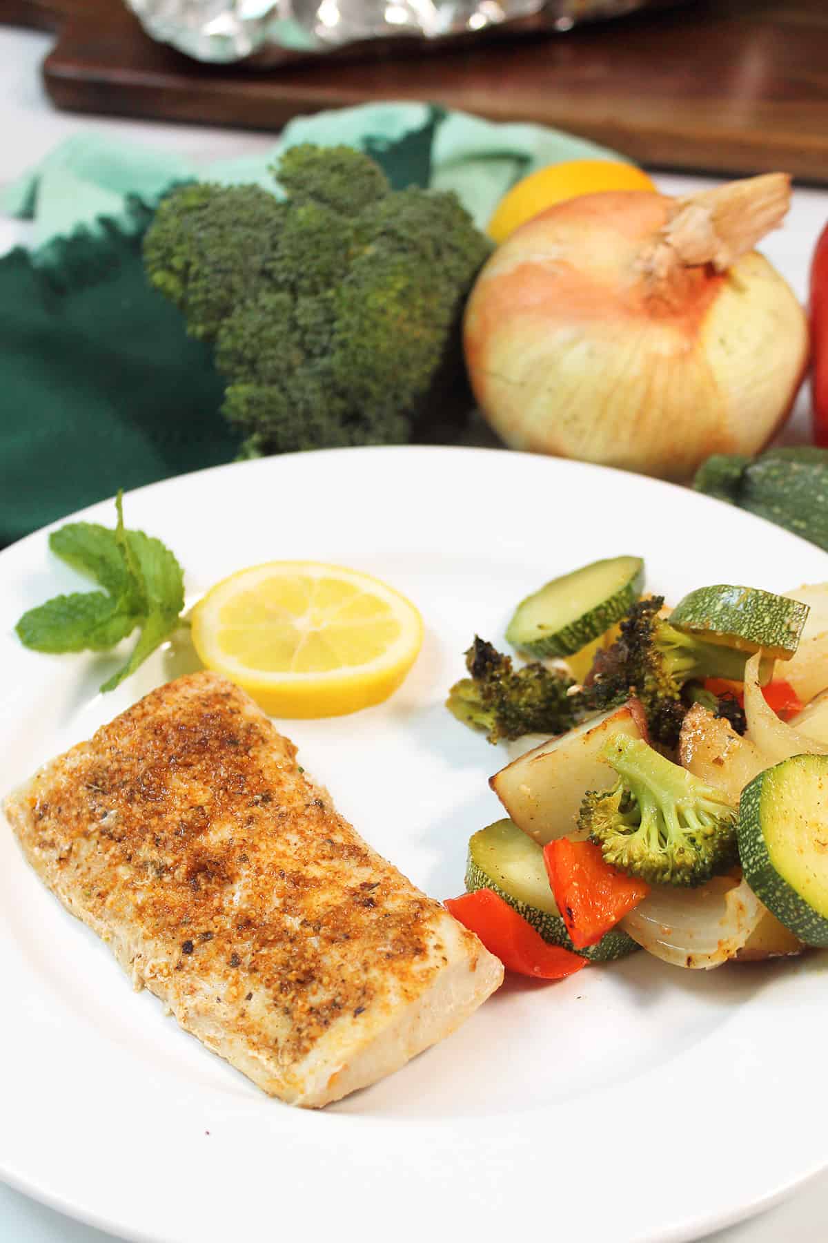 Plated grilled mahi mahi with vegetables.