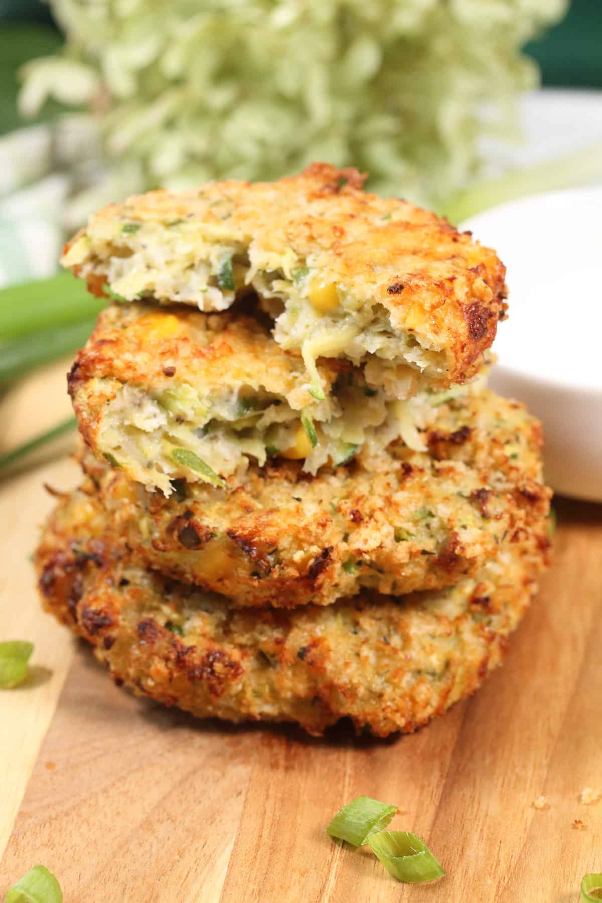 Stacked Air Fryer Zucchini Fritters with halved one on top.