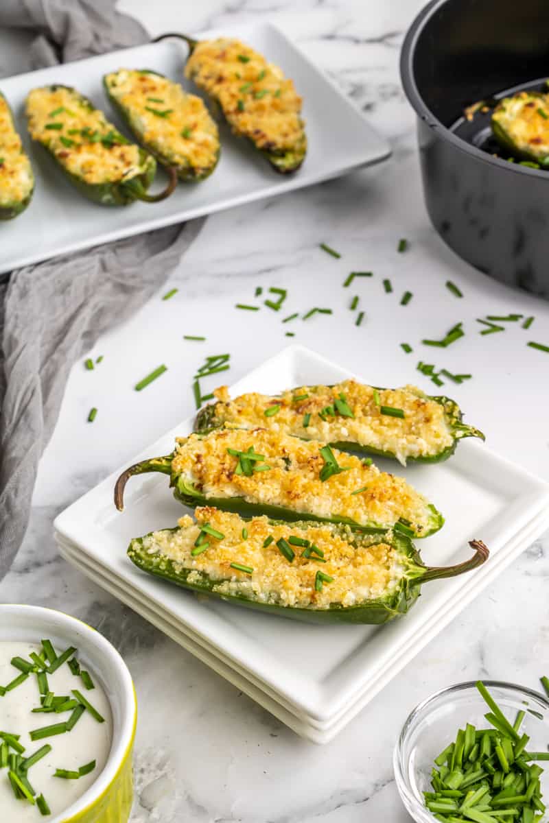 Air Fryer Jalapeno Poppers on white dish garnished with chives.