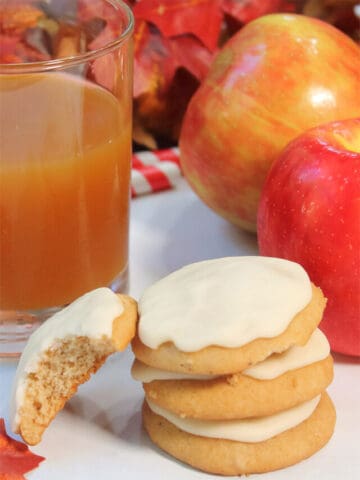 Stack of apple cookies with apple cider.