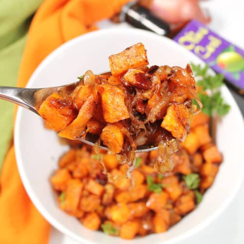 Spoonful of maple roasted sweet potatoes with shallots.