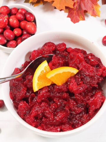 Overhead of cranberry sauce with orange wedges.