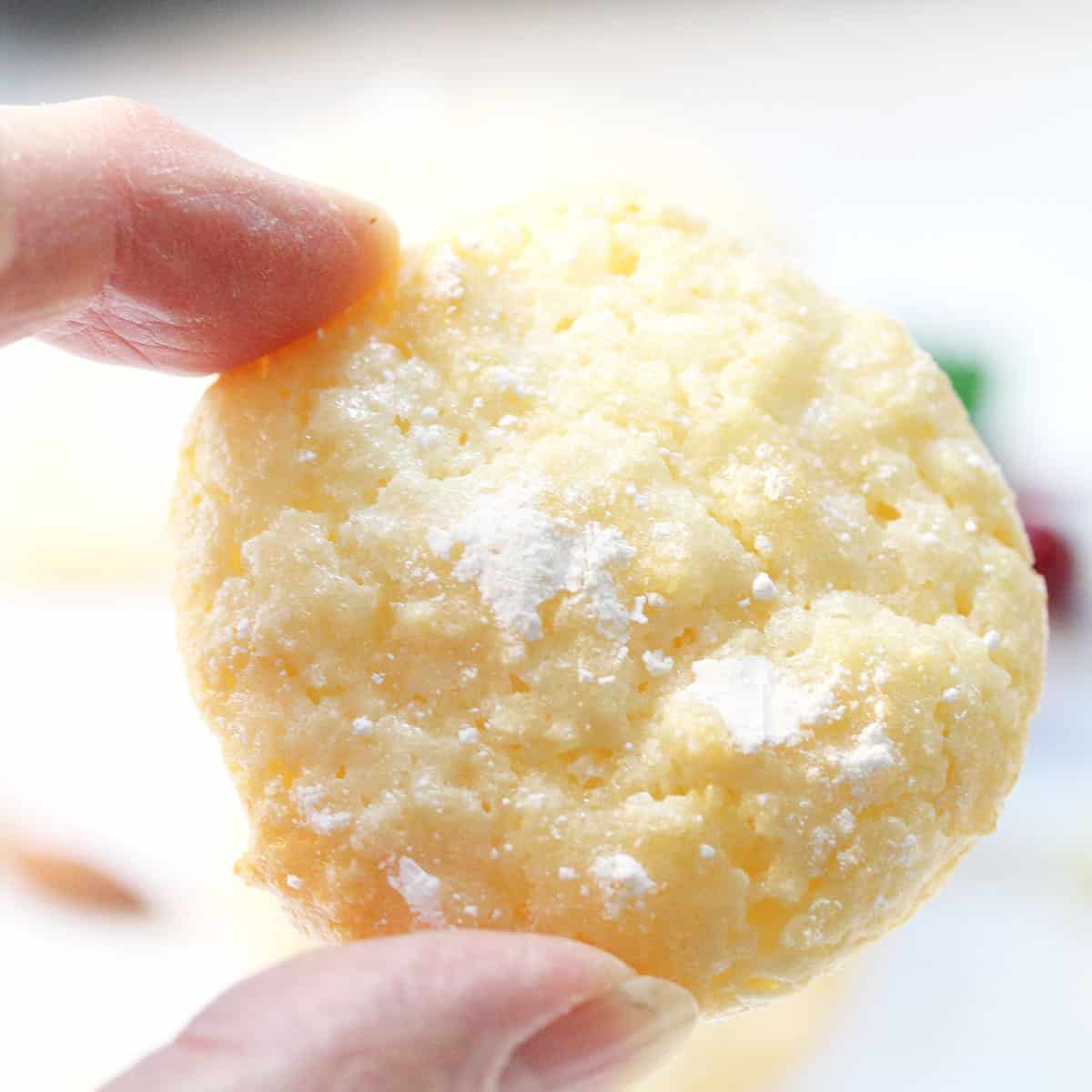 Holding almond paste cookie to show  light and airiness.