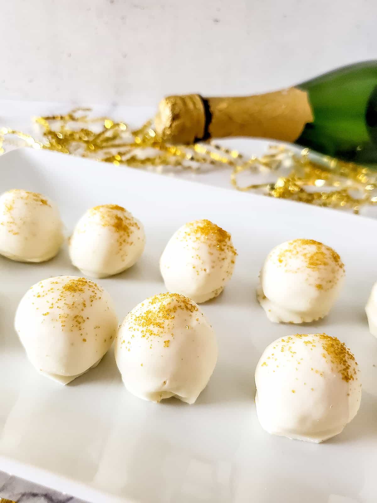 Closeup of truffles with champagne bottle.