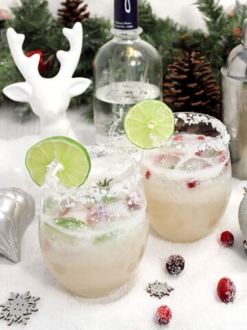 Two White Christmas Margaritas with cranberries and reindeer.