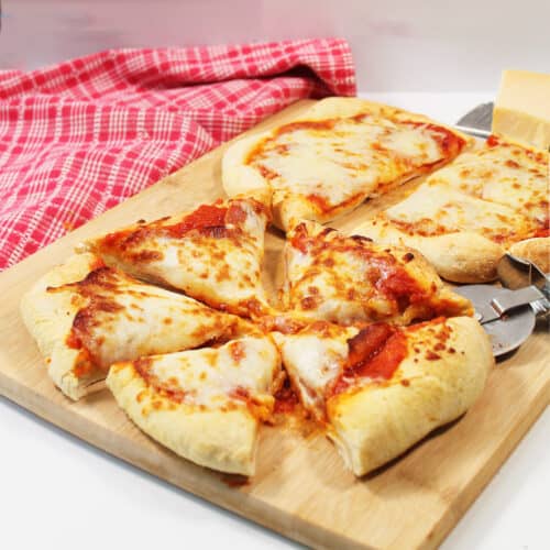 Sliced pizza with red checkered towel.