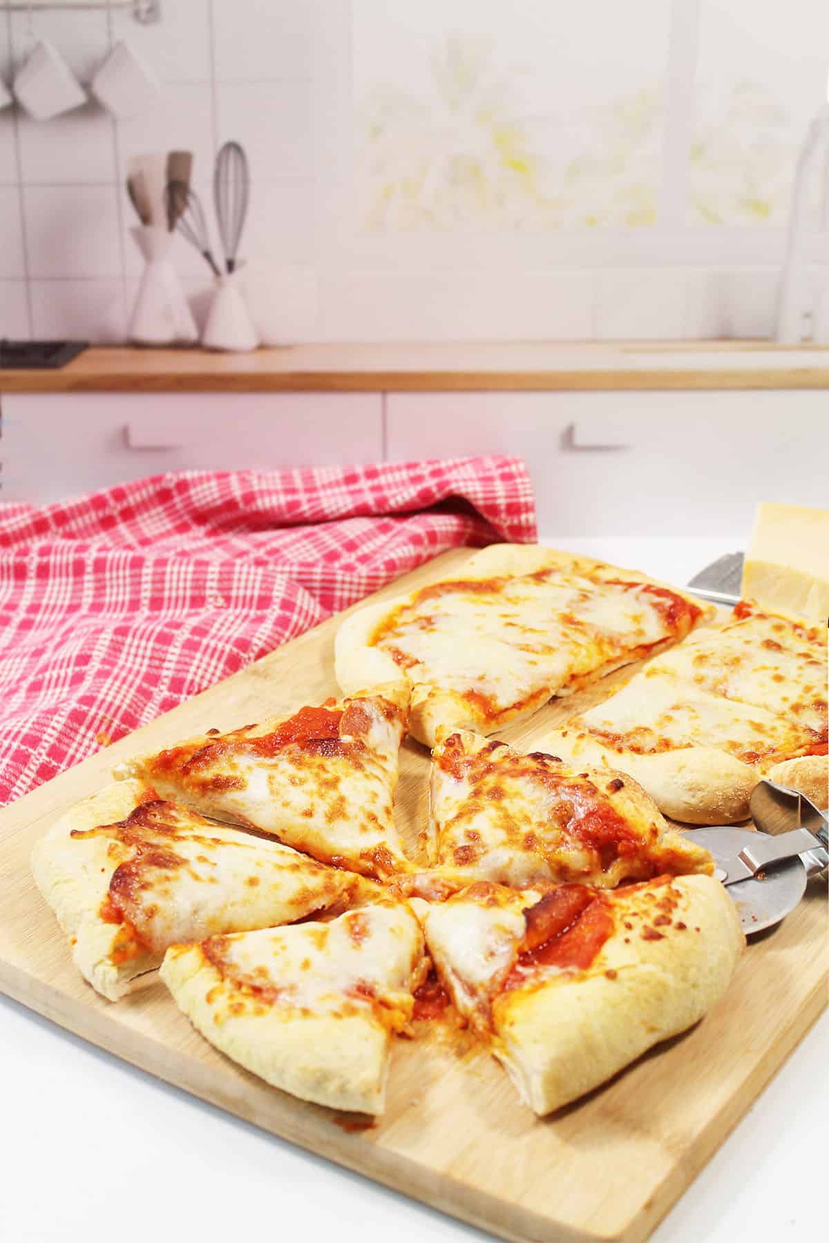 Sliced air fryer pizzas on wooden cutting board.