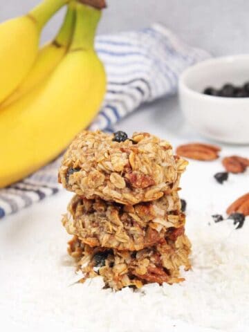 Stack of banana breakfast cookies with bananas.