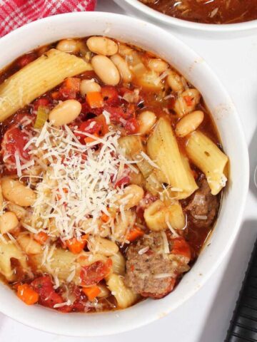 Overhead of bowl of hamburger soup with grated cheese on top.