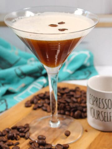 Espresso Martini on wooden board with beans.