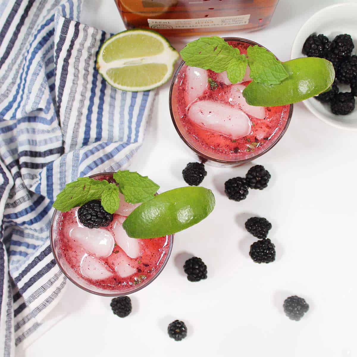 Overhead of two blackberry smash cocktails.