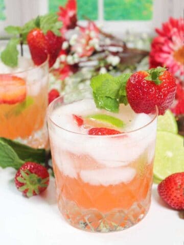 Two strawberry mojitos among flowers.