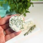 Holding slice of garlic compound butter.