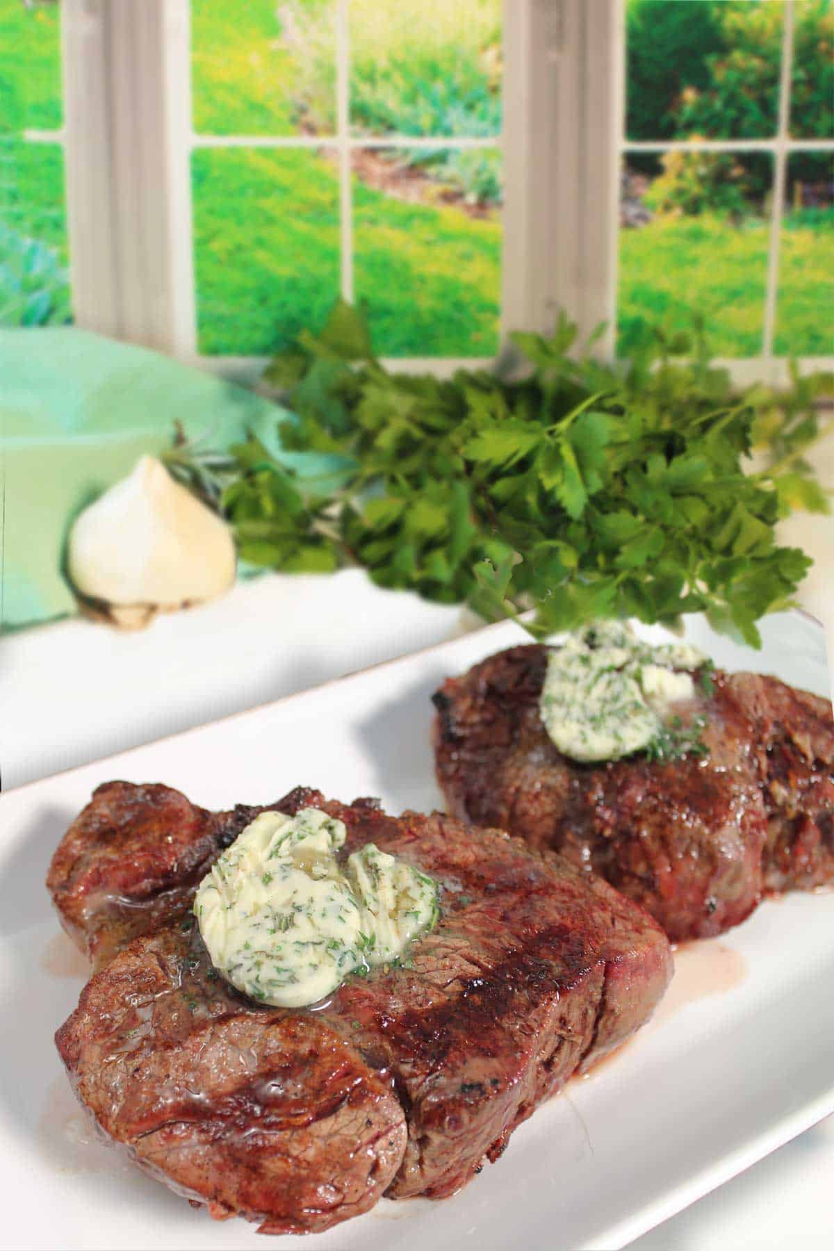 Steaks with melting herbed butter on top.