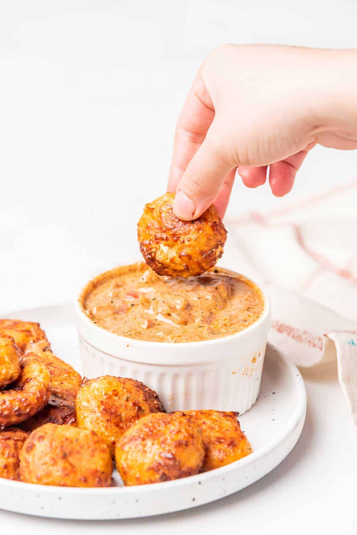 Dipping pizza bite into creamy marinara.