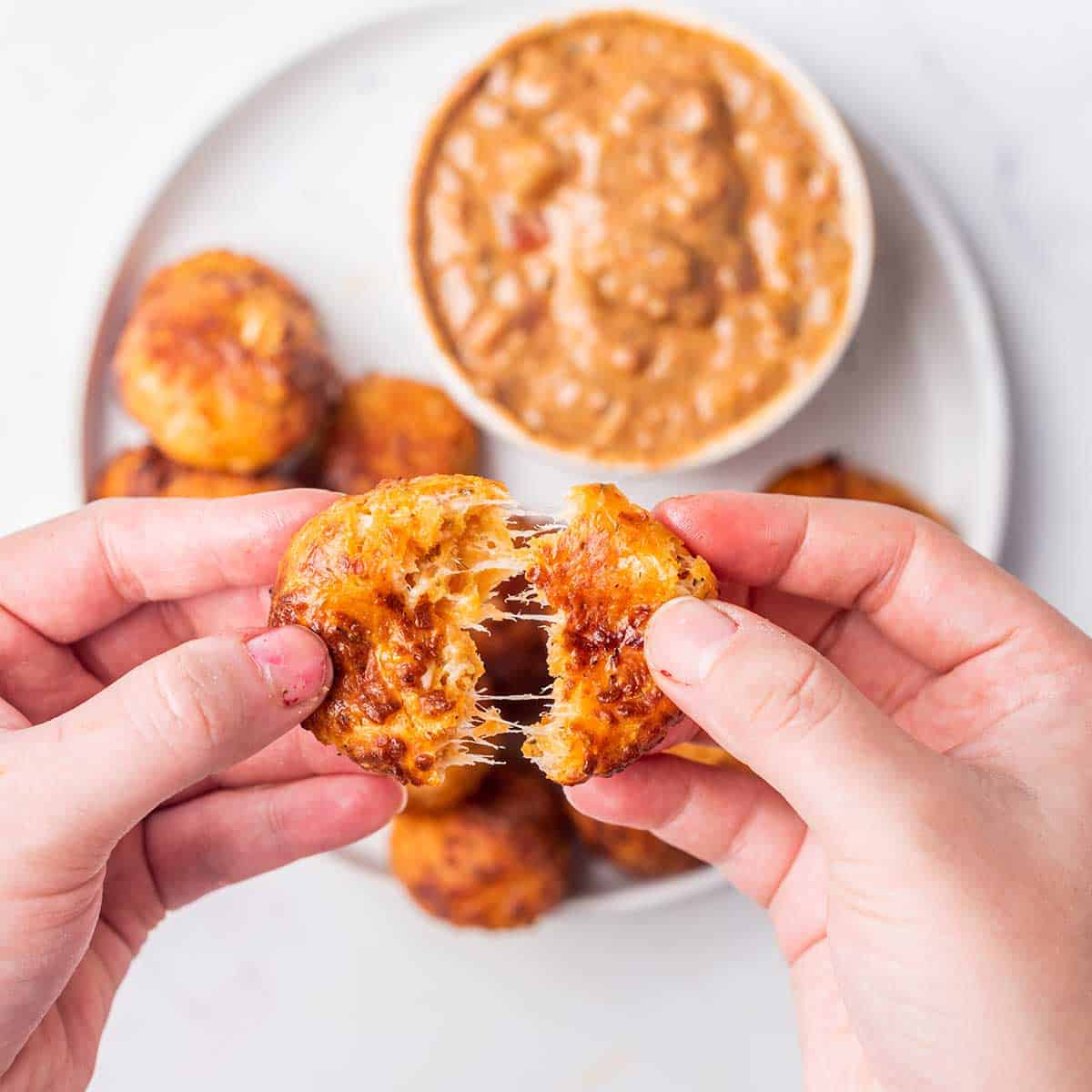 Pulling apart cheesy pizza bite.