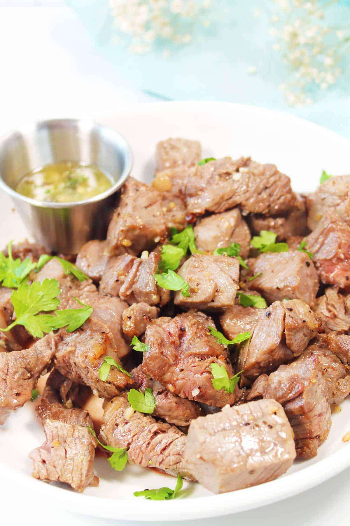 Air Fryer Steak Bites in serving bowl with butter dipping sauce.
