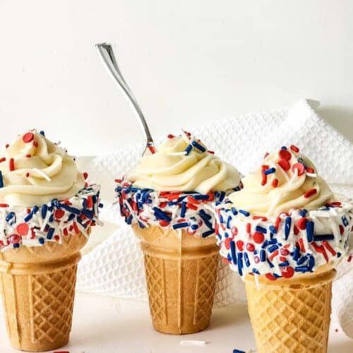 Three cheesecake mousse cones with spoon in one.