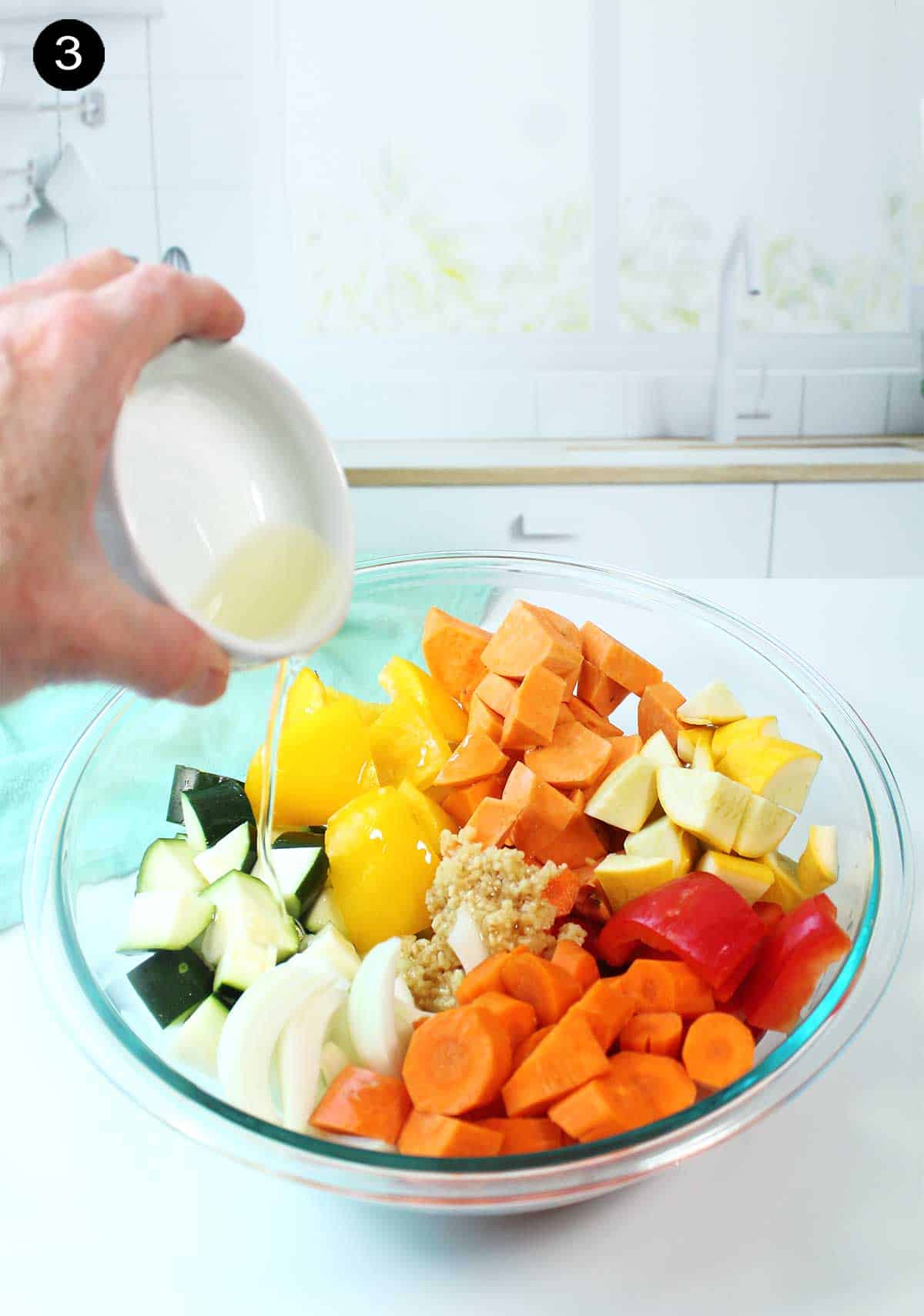 Drizzling olive oil over cut veggies.