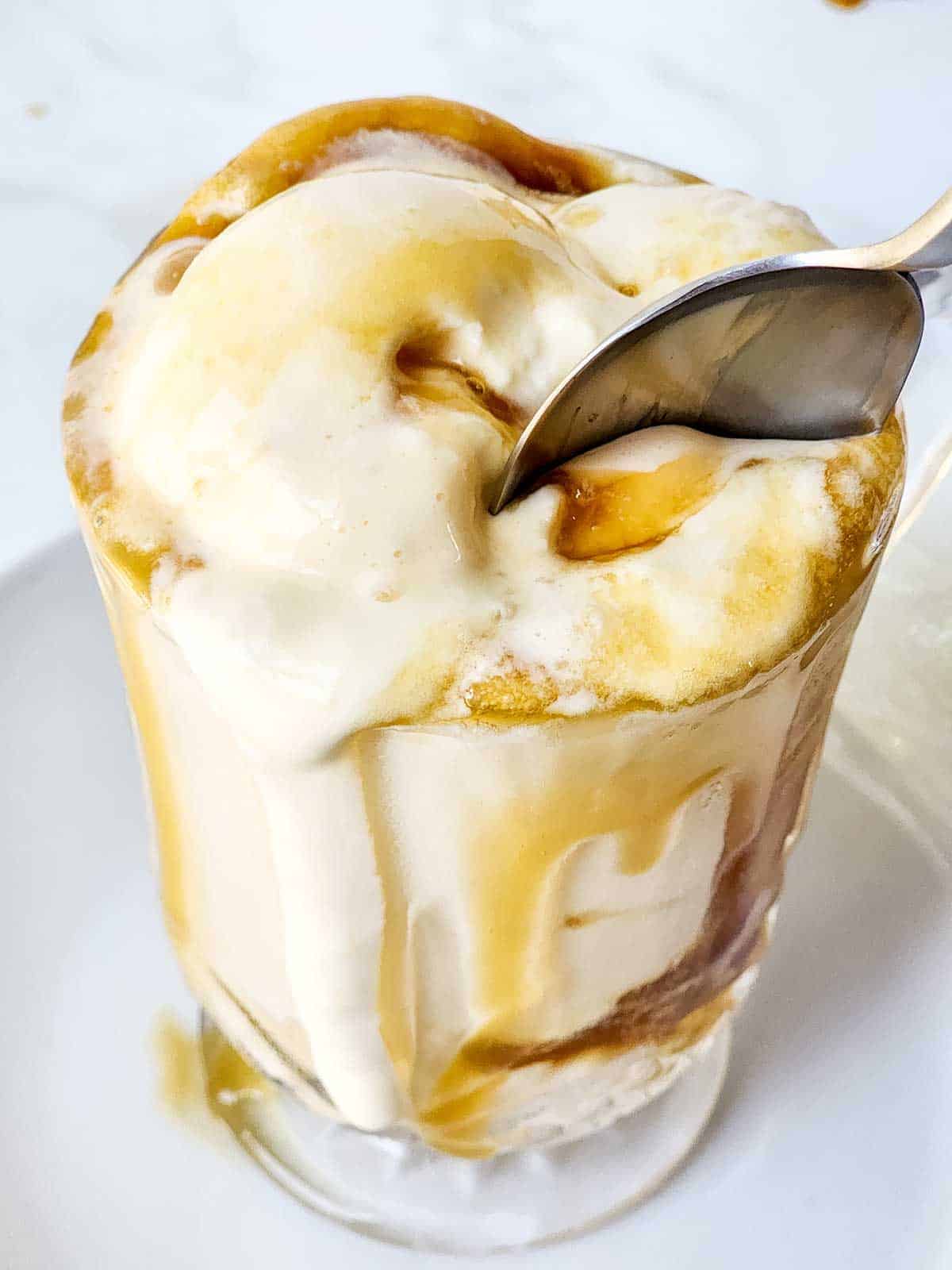 Digging into ice cream float with spoon.