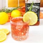 Cranberry Whiskey Sour with lemon and rosemary garnish.