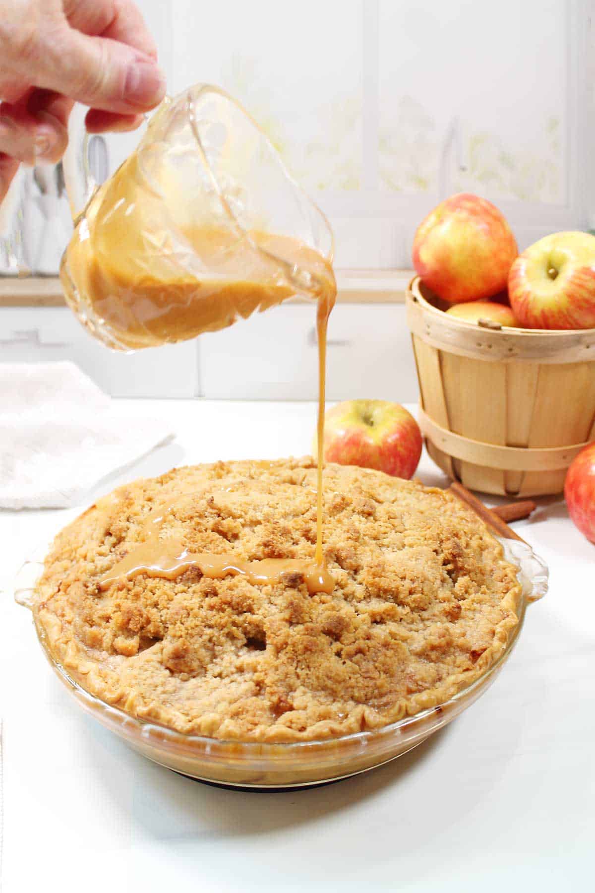 Pouring caramel topping on baked pie.