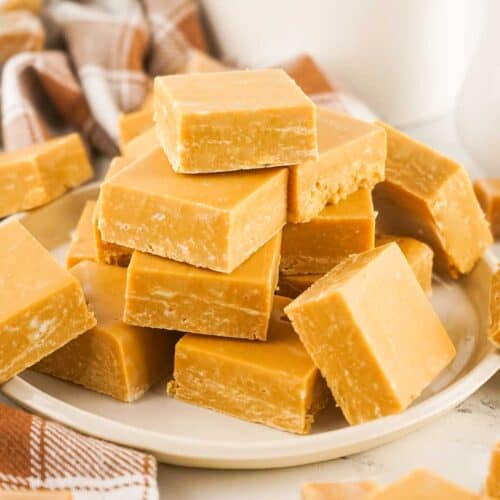 Two Ingredient Caramel Fudge stacked on plate.