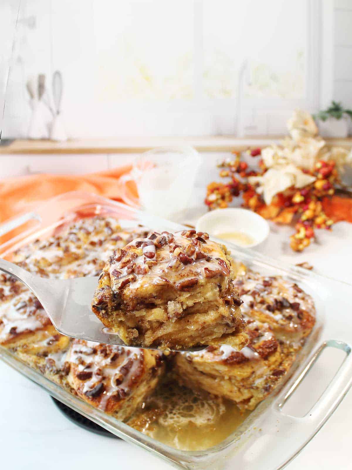 Lifting serving of French Toast casserole out of baking dish.