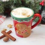 Gingerbread Latte next to cinnamon sticks and nutmeg.