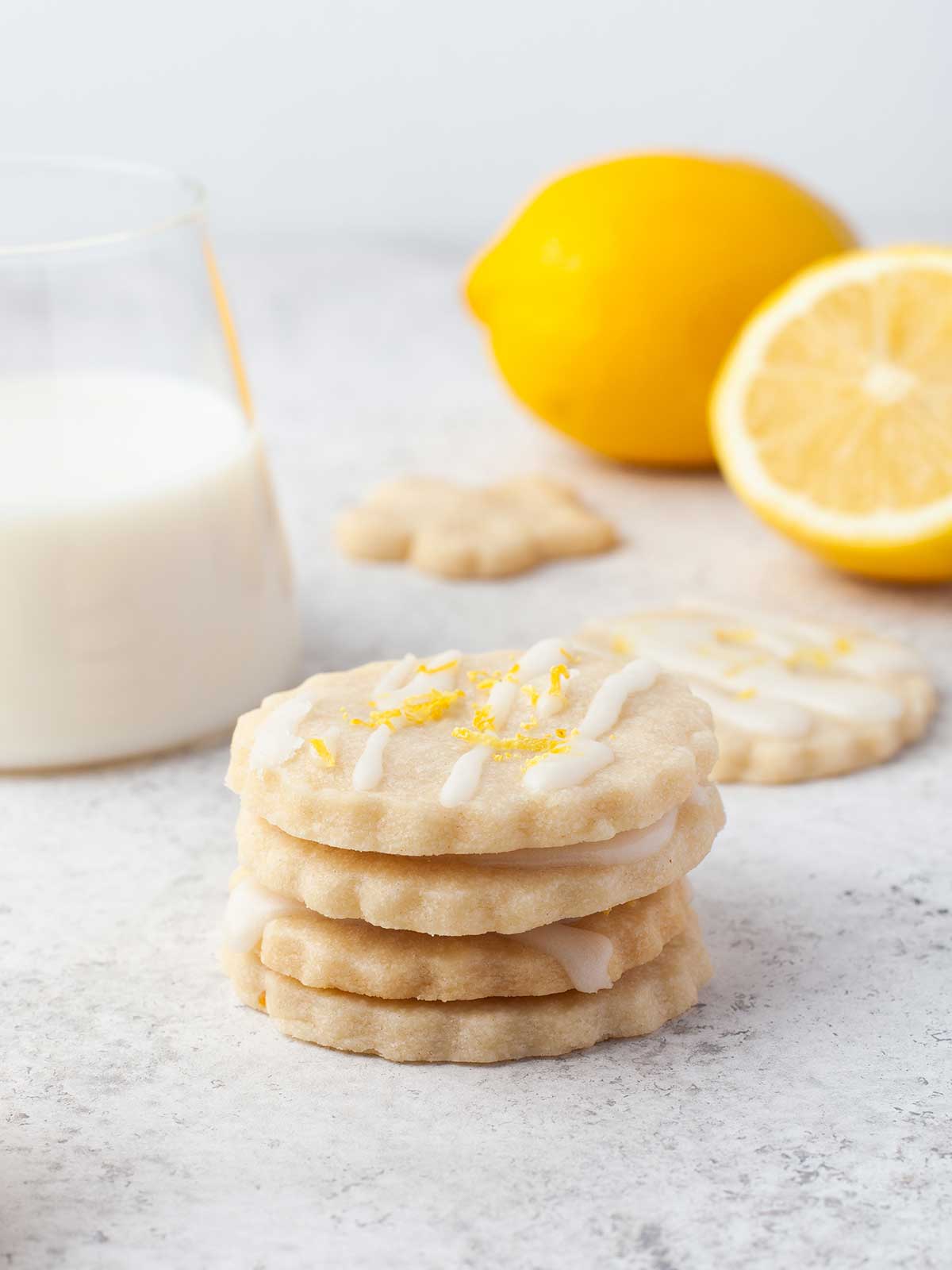 Stacked shortbread cookies showing lemon icing with zest.