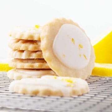 Stacked Lemon Shortbread Cookies with one cookie leaning on stack.