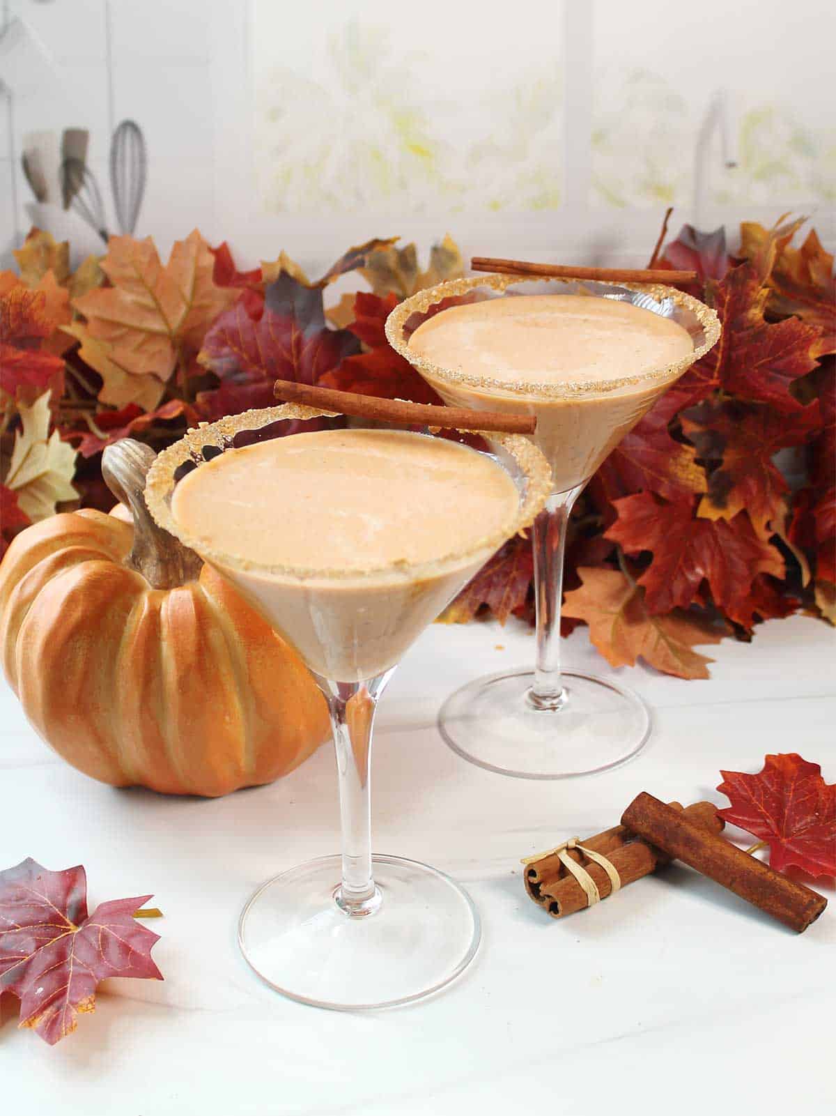 Two finished pumpkin spice martini cocktails without garnish.