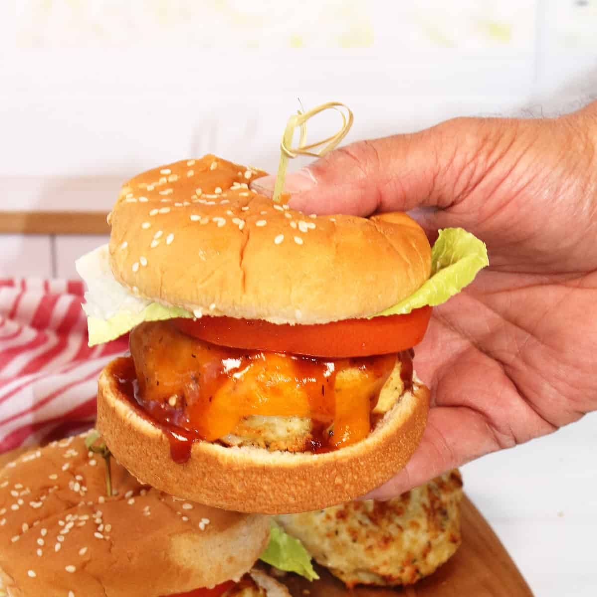 Holding burger with garnishes.
