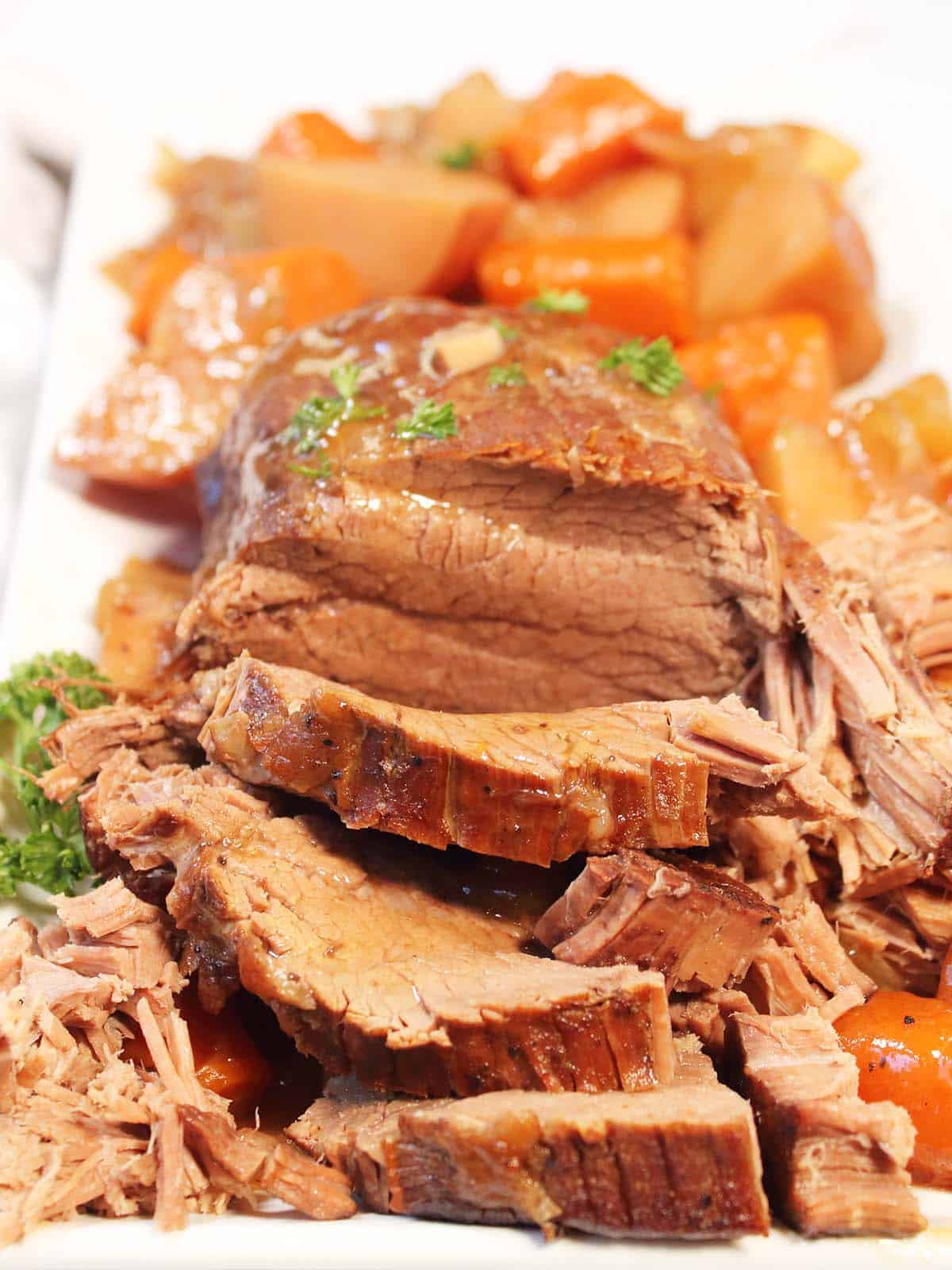 Sliced slow cooker pot roast on platter.