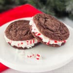 Two Oreo sandwich cookies on plate.