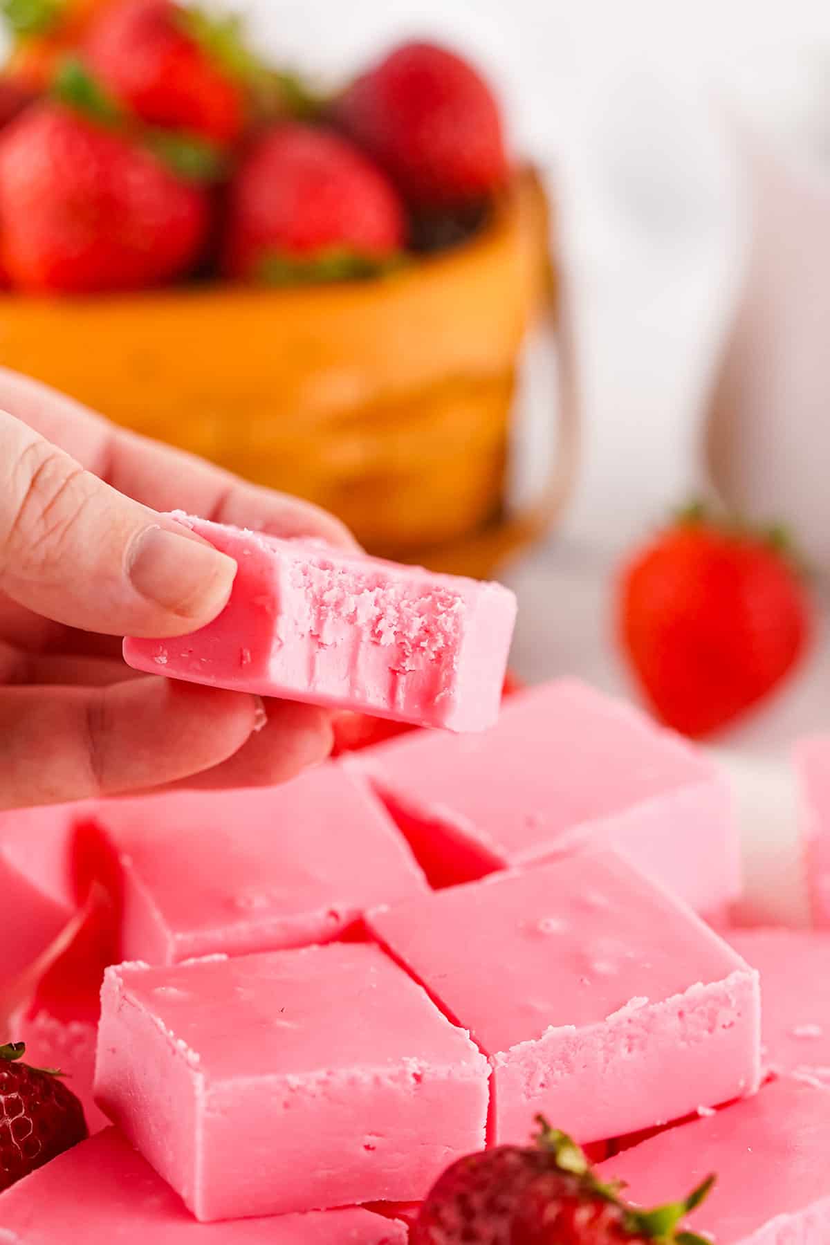 Holding piece of fudge with bite out of it.