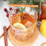 Cocktail garnished with cinnamon stick and lemon slice.