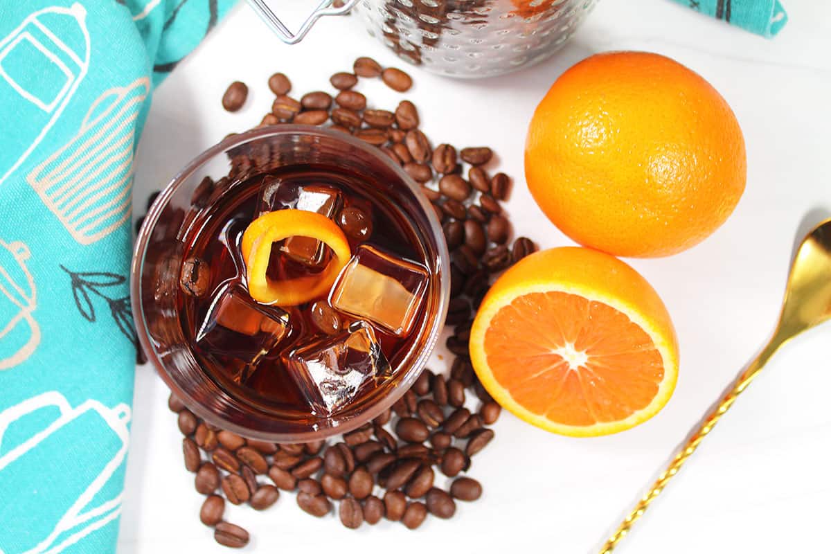 Bourbon cocktail overhead with oranges and coffee beans.