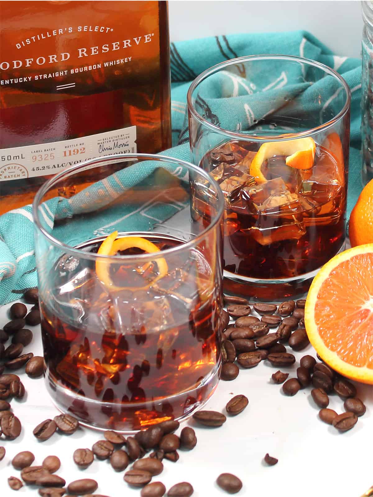 Two coffee old fashioned cocktails with orange twist.