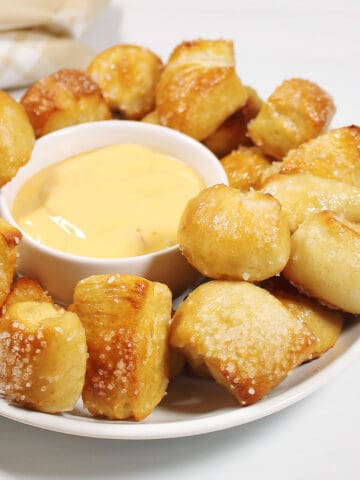 Soft pretzel bites surrounding cheese dip.