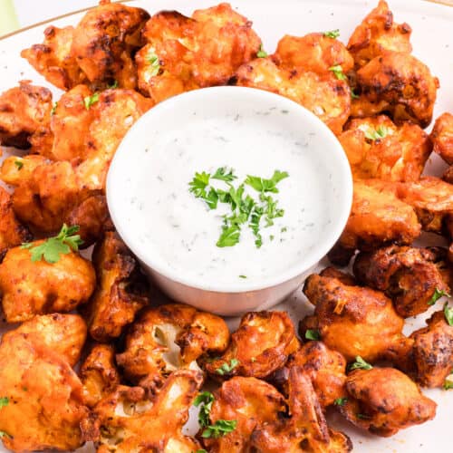 Closeup of cauliflower wings on plate with dip.