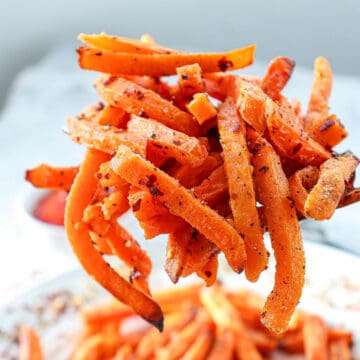 Batch of air fryer sweet potato fries on serving spoon.