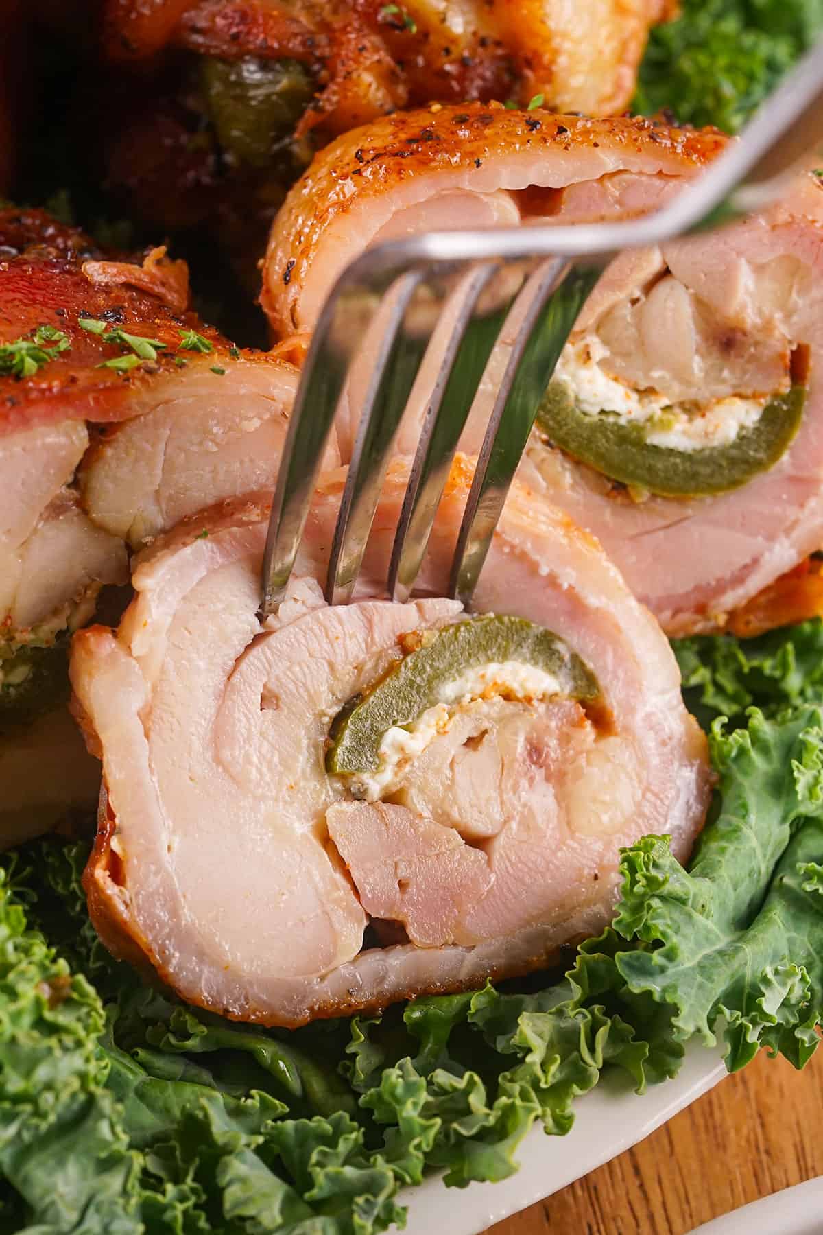 Closeup of inside of cut chicken thigh with fork in it.