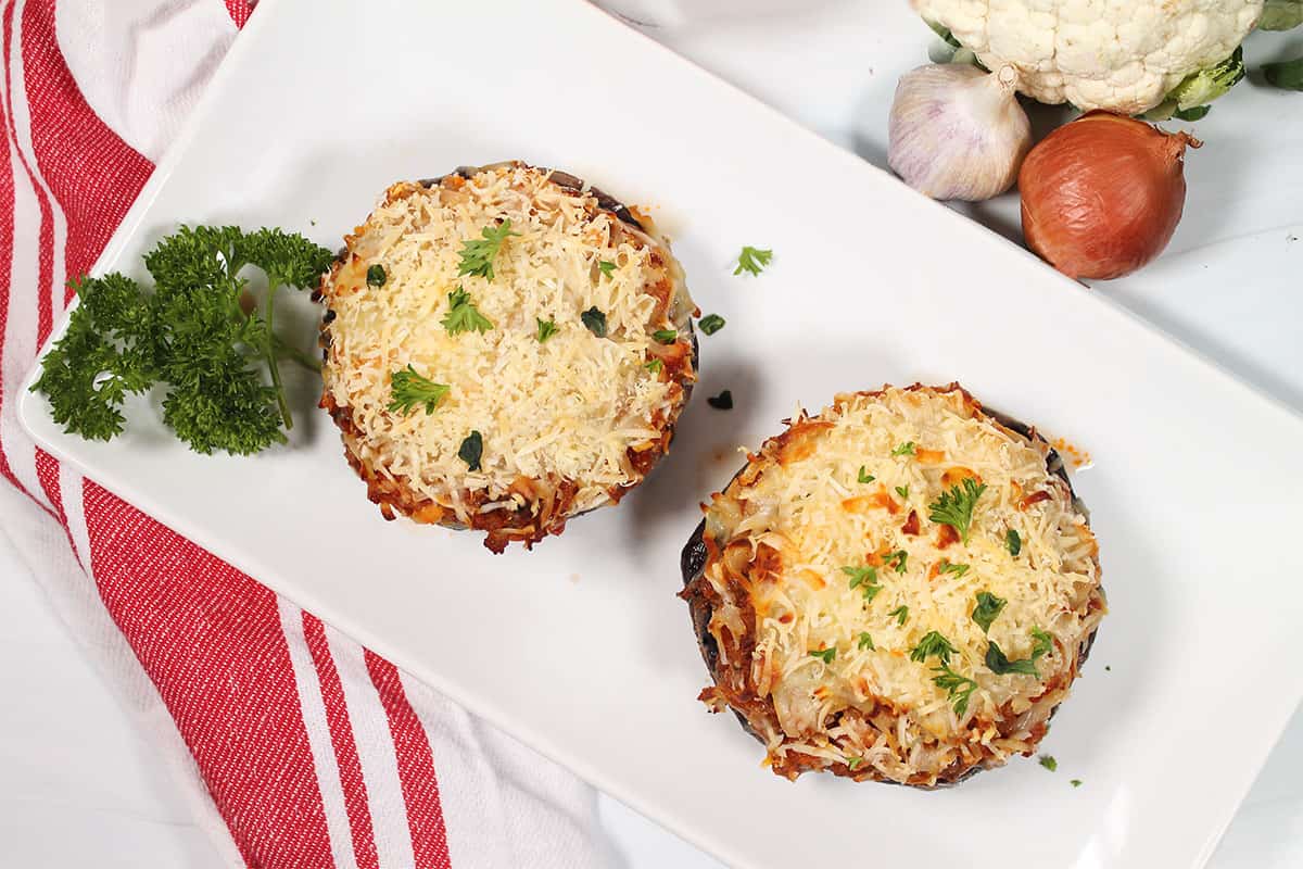 Overhead of cheesy stuffed portobello mushrooms.