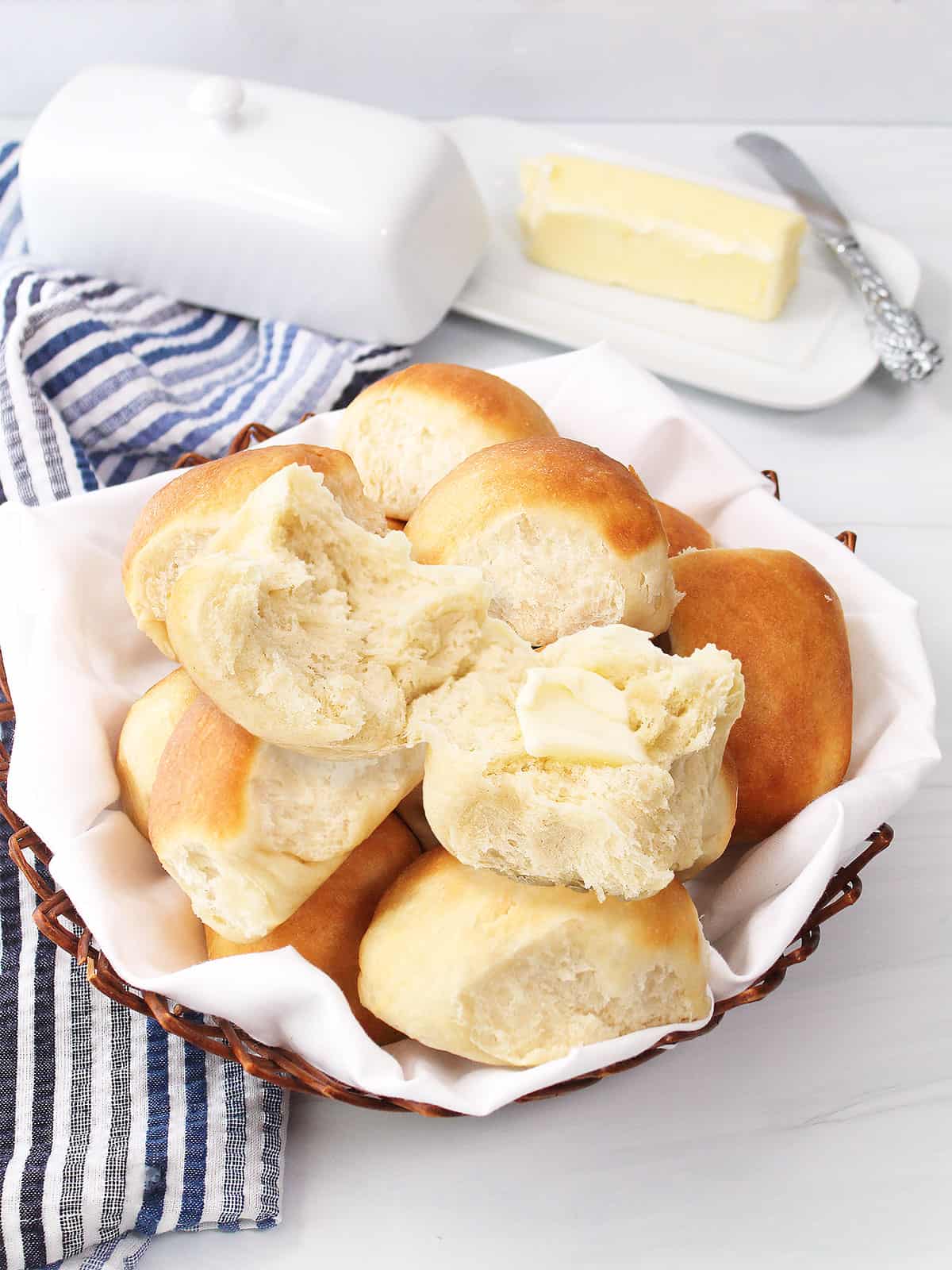 Buttered roll on top of rolls in basket.