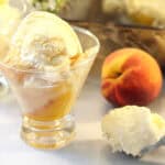 Cake Mix Peach Cobbler in dish topped with ice cream.
