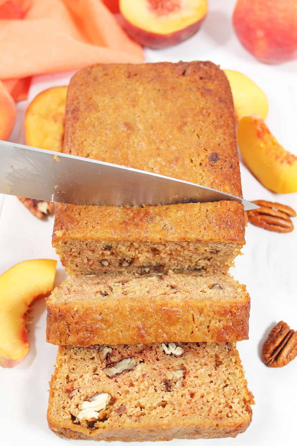 Slicing peach bread with nuts.